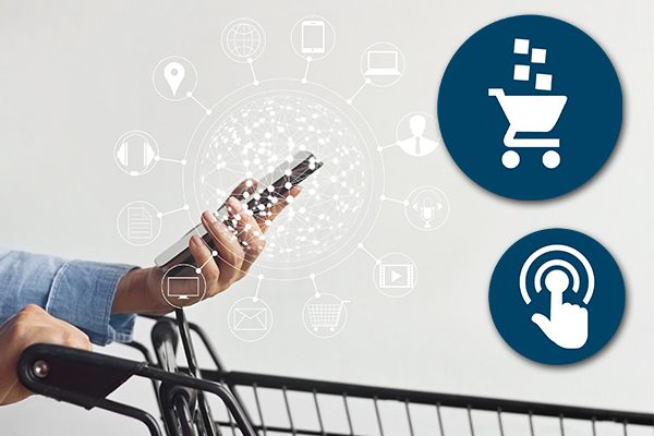 Person pushing shopping cart and holding mobile phone with one hand.